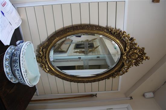 A large Victorian oval gilt wall mirror, 4ft 7in.